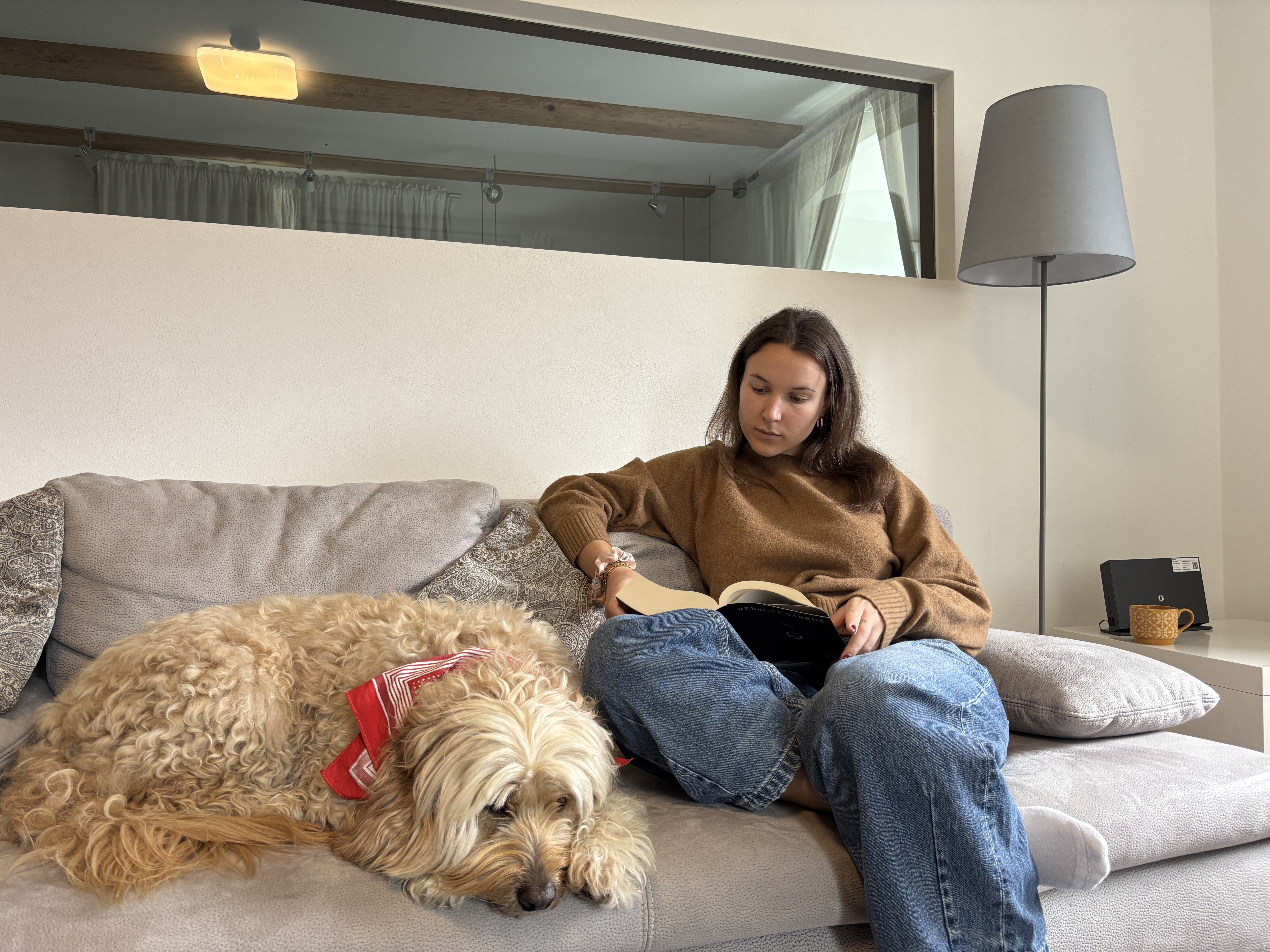Schülerin und Hund entspannen auf dem Sofa